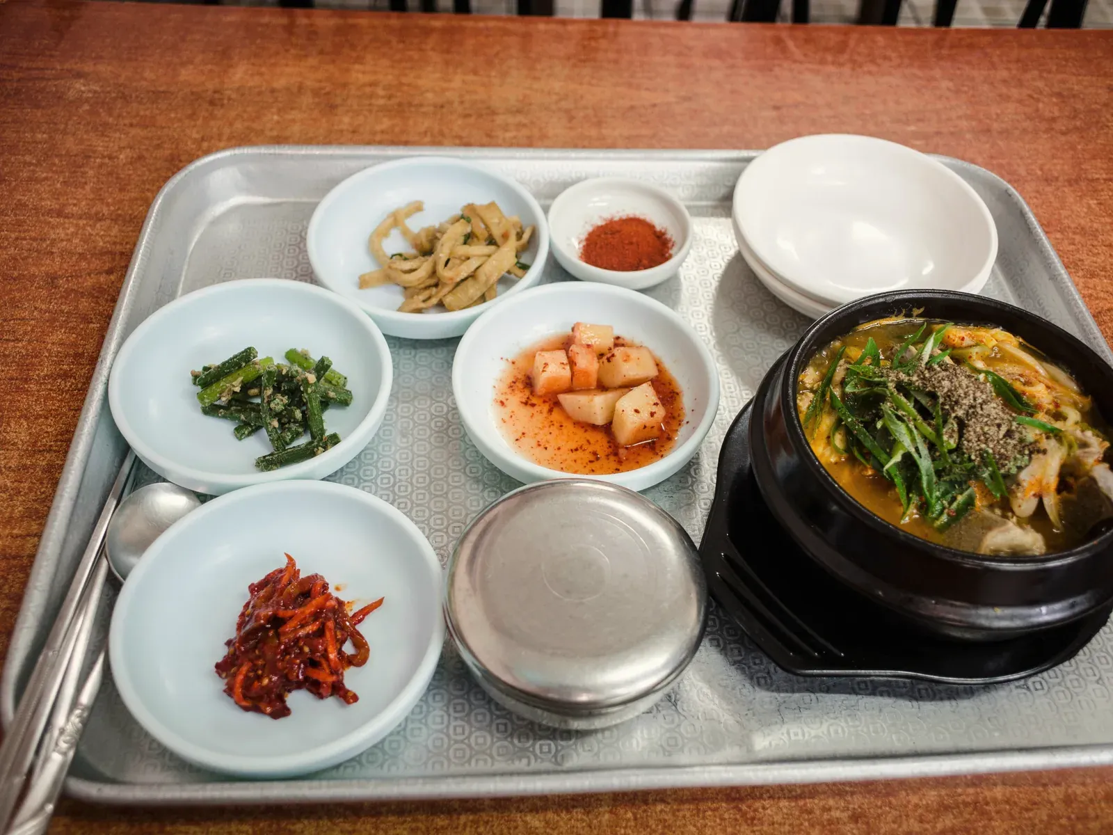 A tray with a bowl of gukbap, rice, kkakdugi and small side dishes