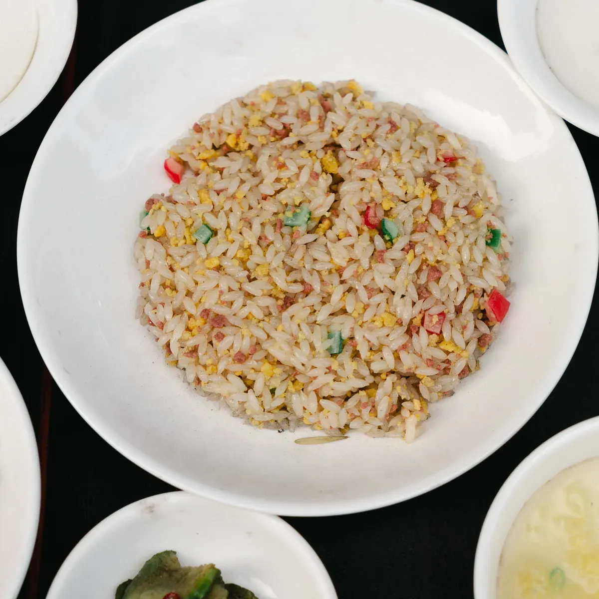 A plate of egg fried rice with scallion and red pepper