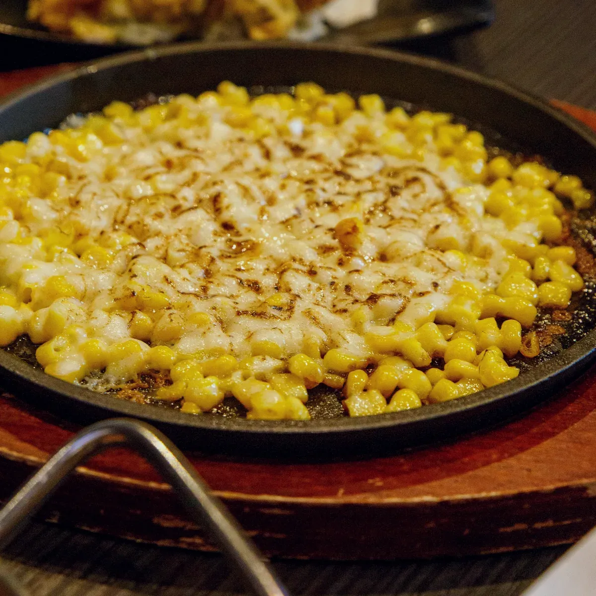 Corn cheese with melted mozzarella in a small skillet