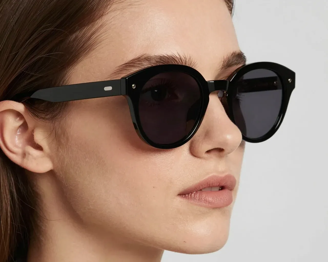 A woman wearing ECLIPSE 01 in the Global fit: standard pads on a higher bridge, the frame resting closer to her face