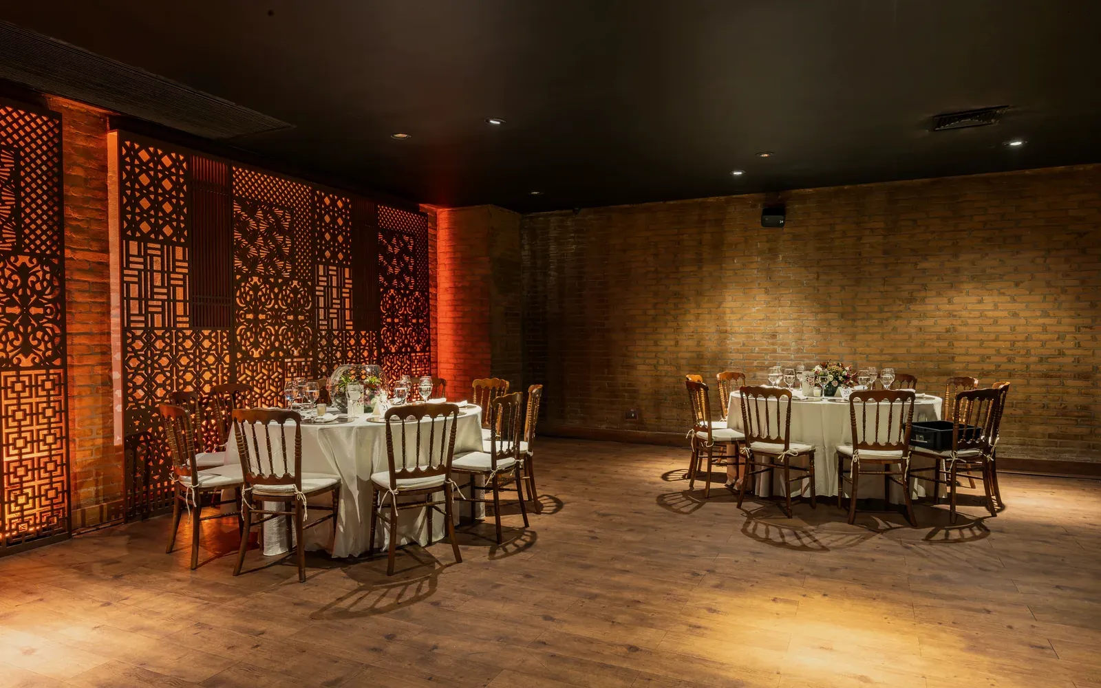 Unhae Hall: round tables set for dinner beside carved lattice panels