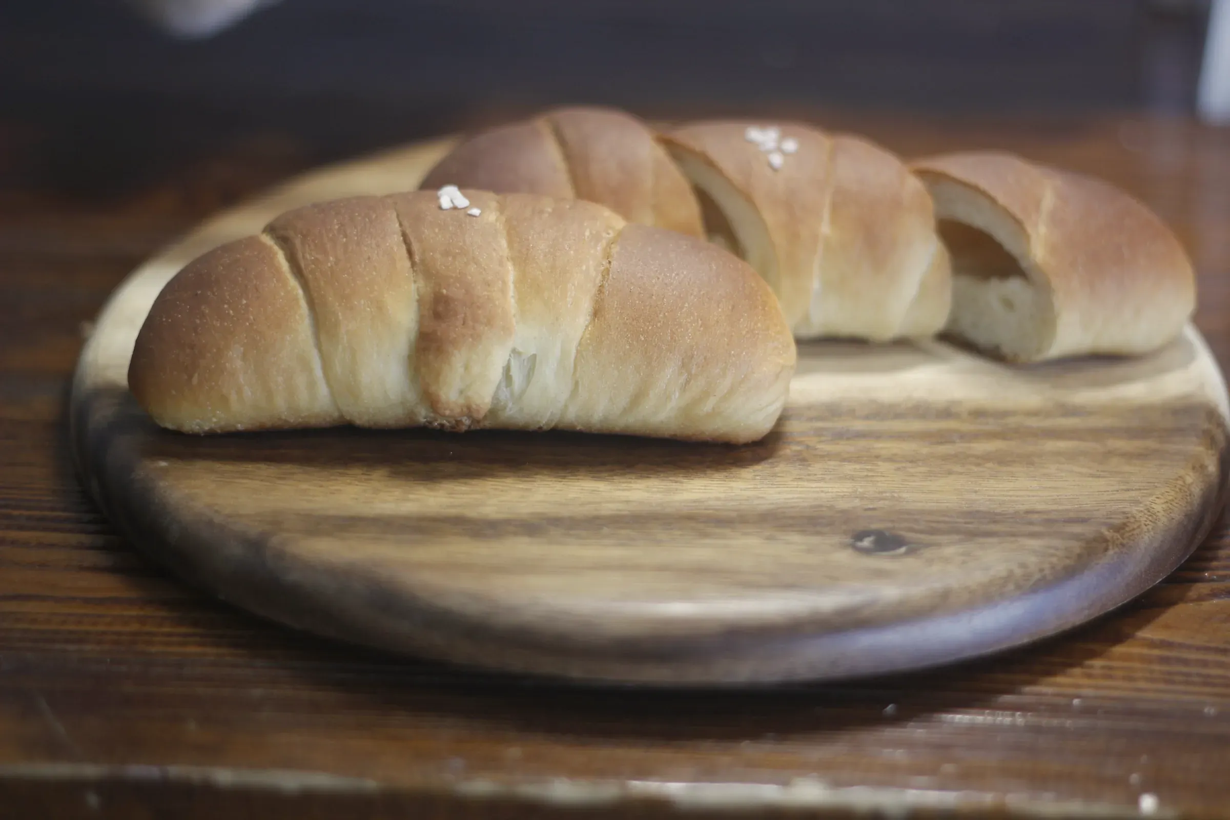 Salt butter rolls on a round wooden board