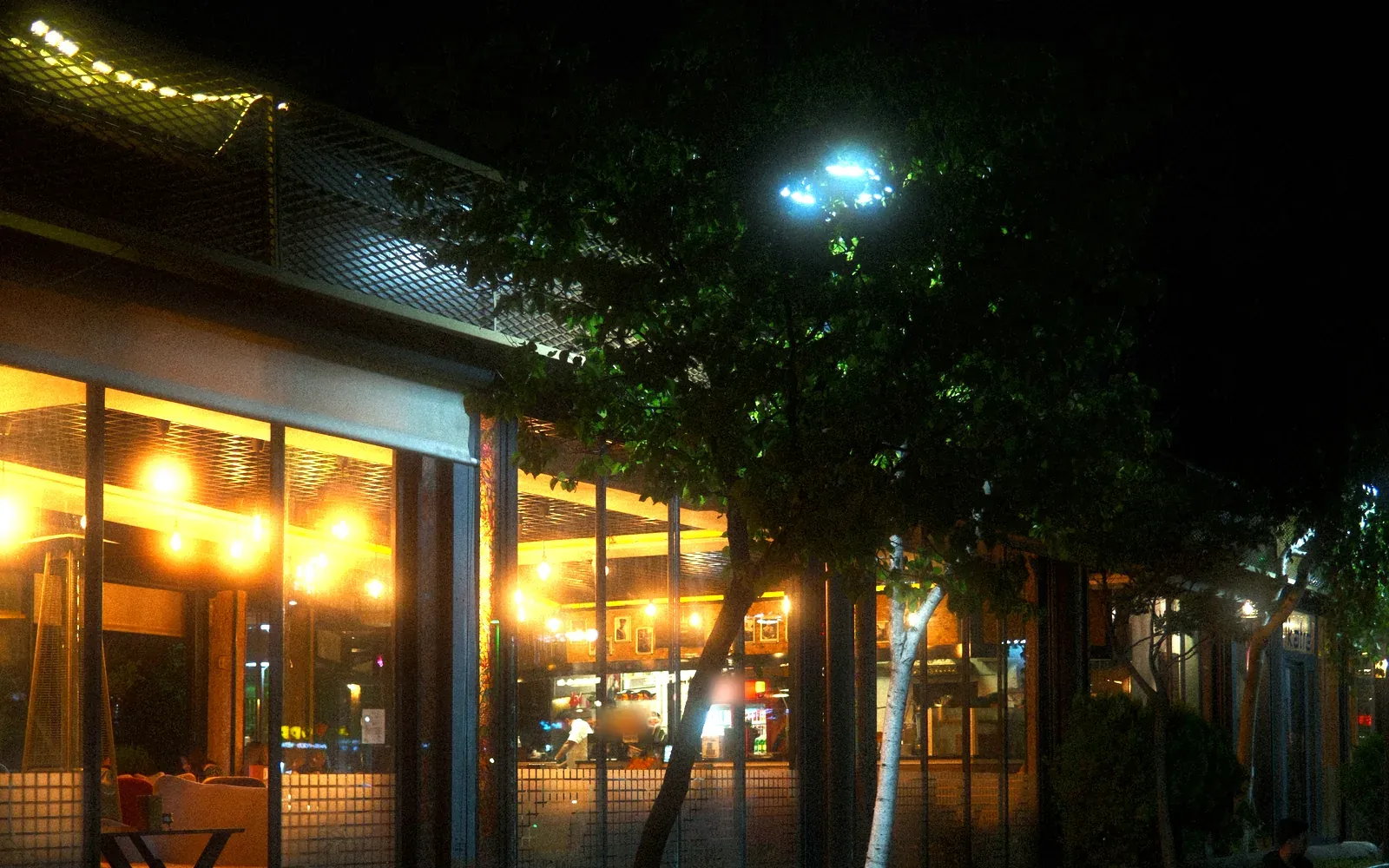 The Irvine location at night on an outdoor plaza under string lights