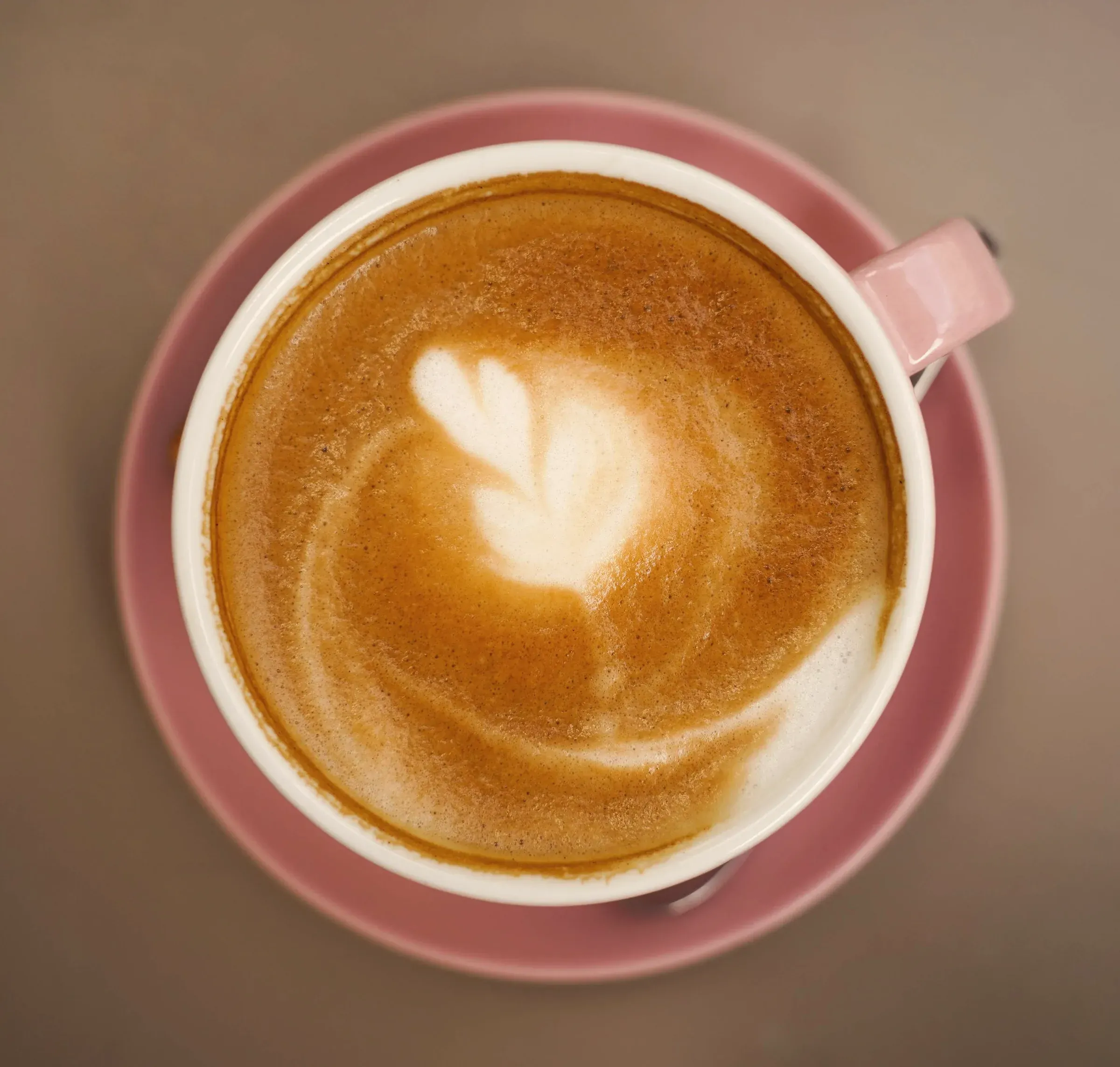 An oat milk latte with latte art, seen from above