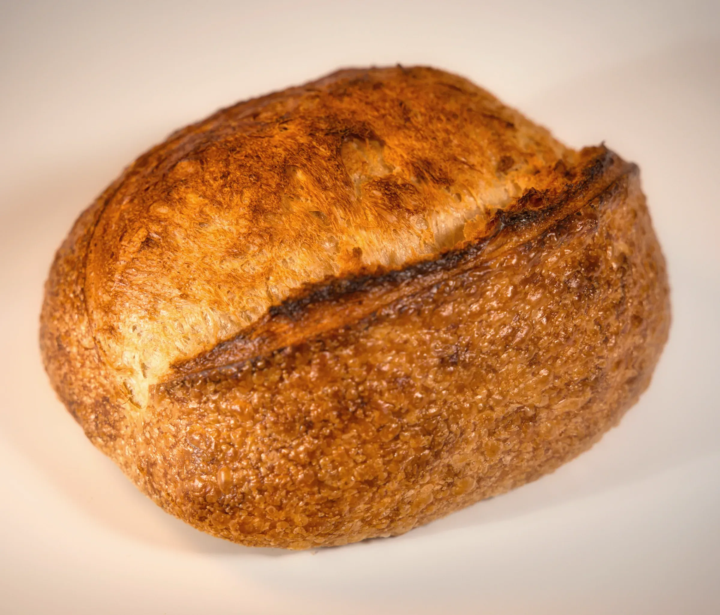 A round floured country loaf with a deep score