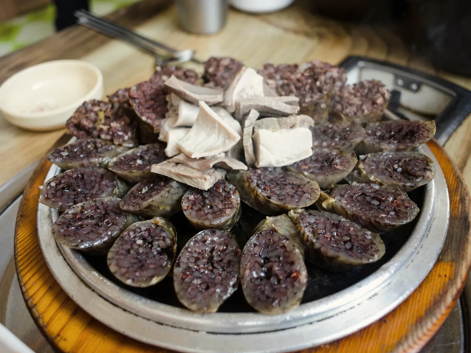 A platter of sliced Korean blood sausage with lung and stomach on a steamer plate