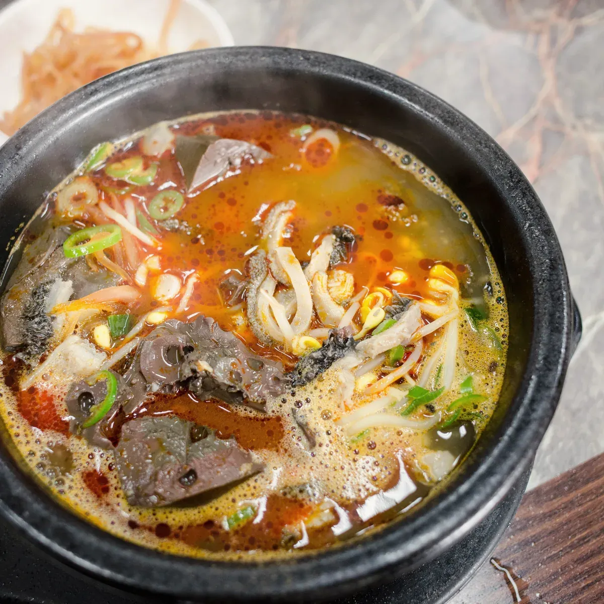 Red-tinged pork offal soup with bean sprouts and green onion