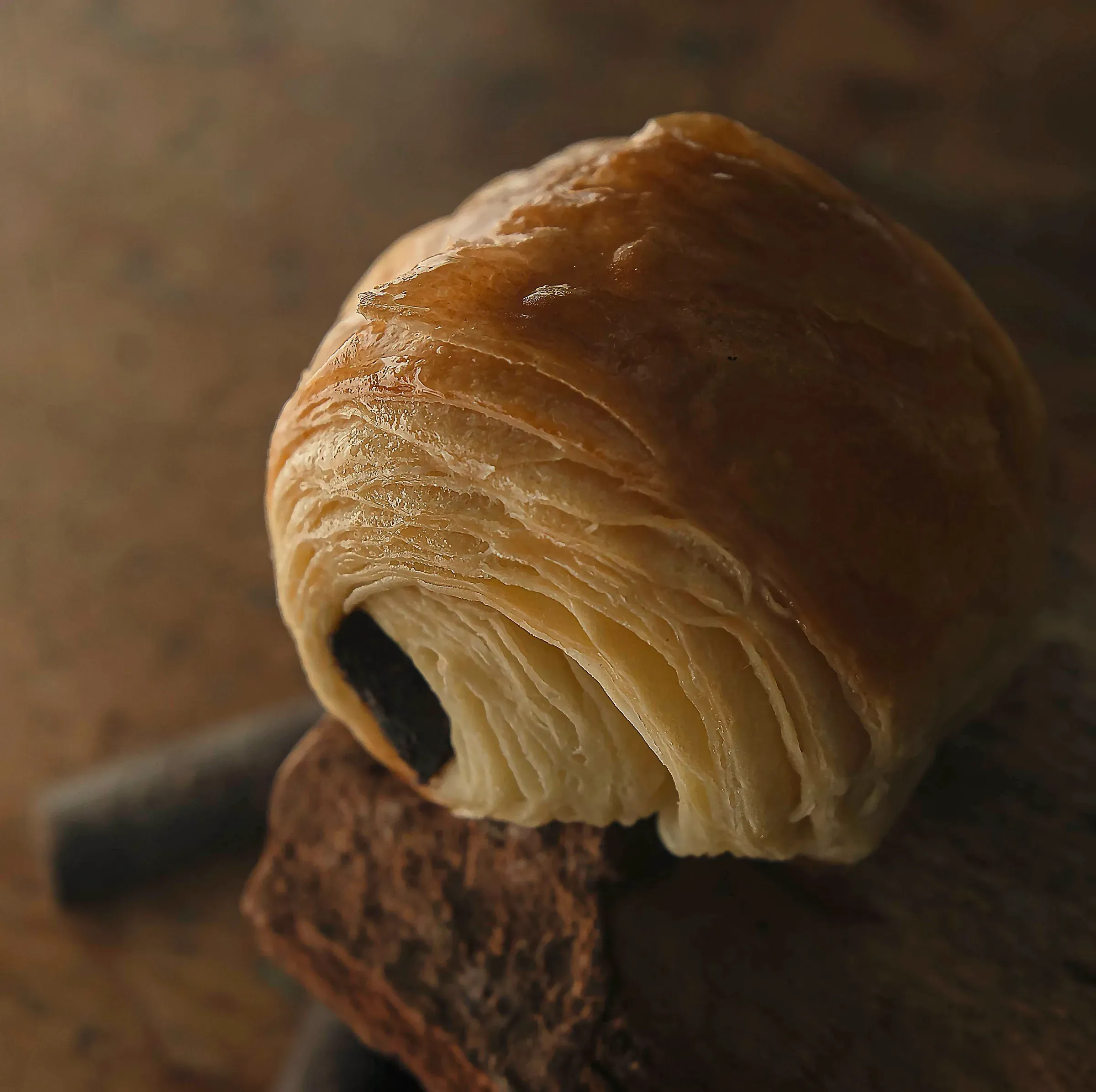 A pain au chocolat on a rustic wooden surface
