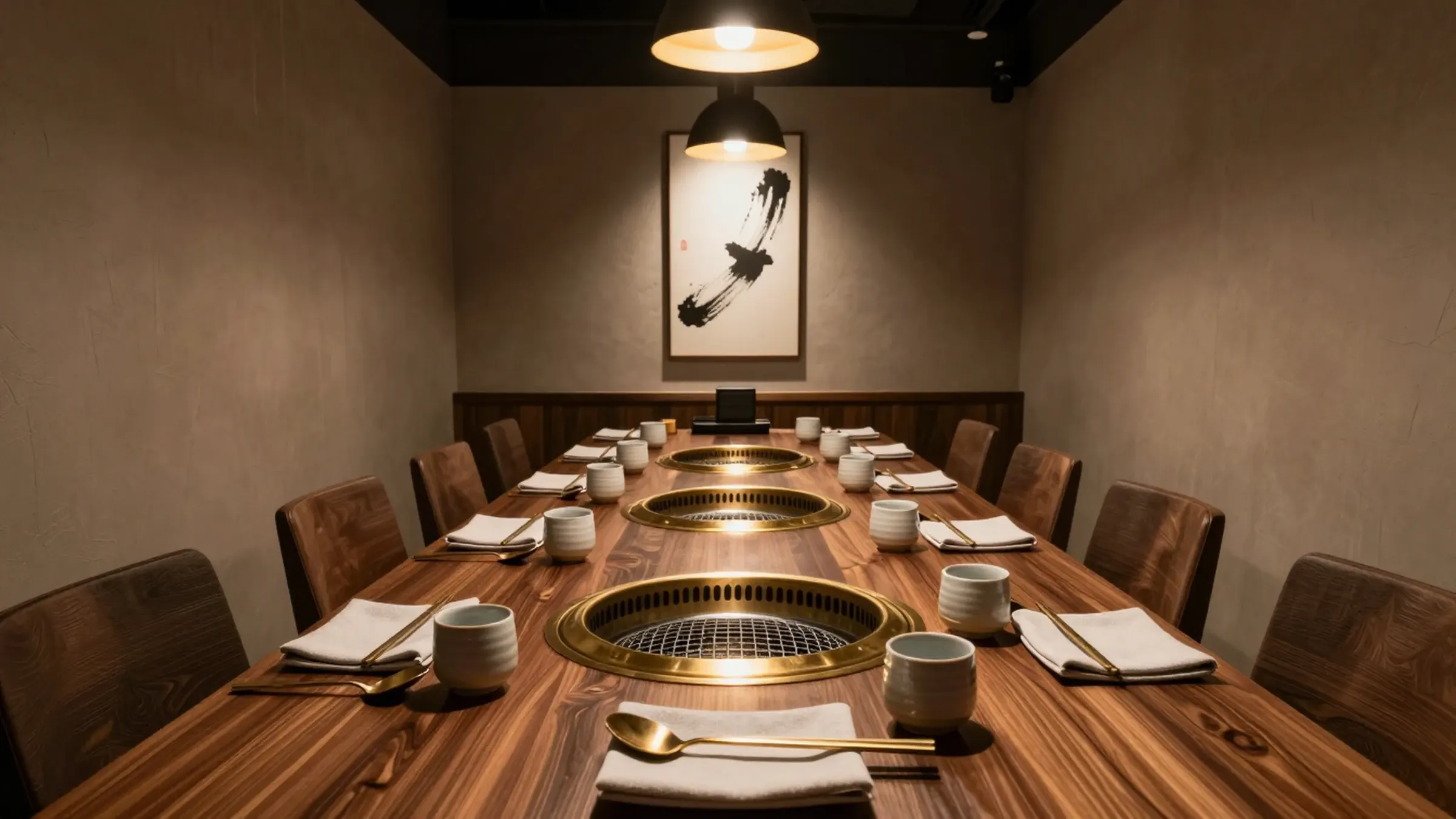 A private dining room set for a large party around two grills