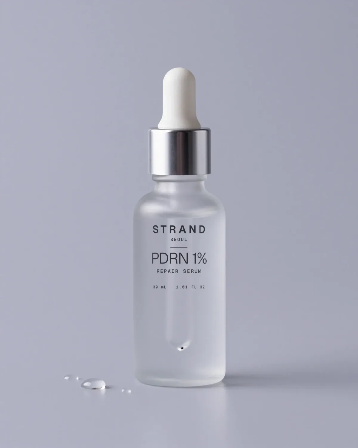 PDRN 1% Repair Serum: a frosted glass dropper bottle with a silver collar, with the STRAND SEOUL label