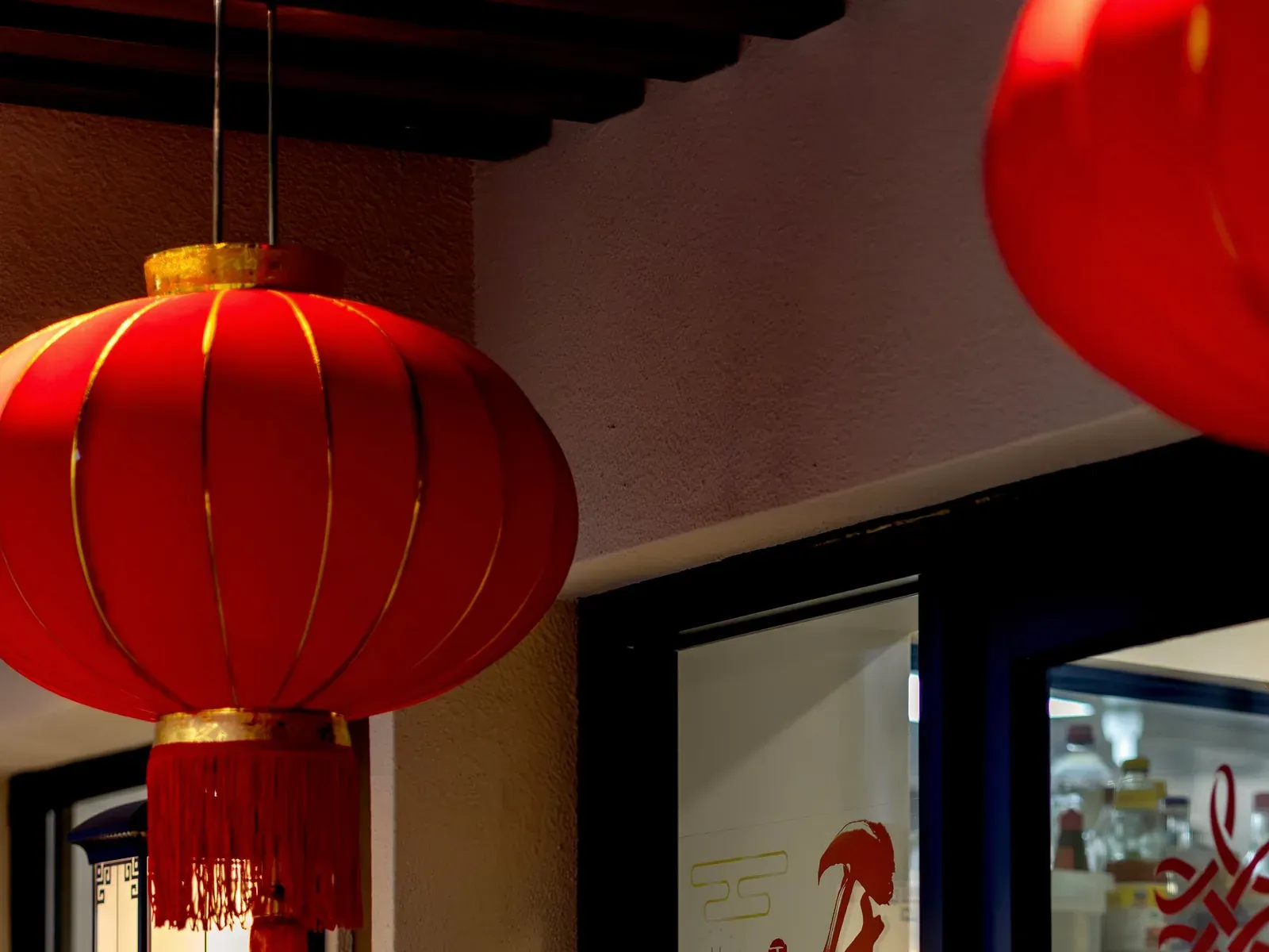 A red and gold lantern hanging by the shop window