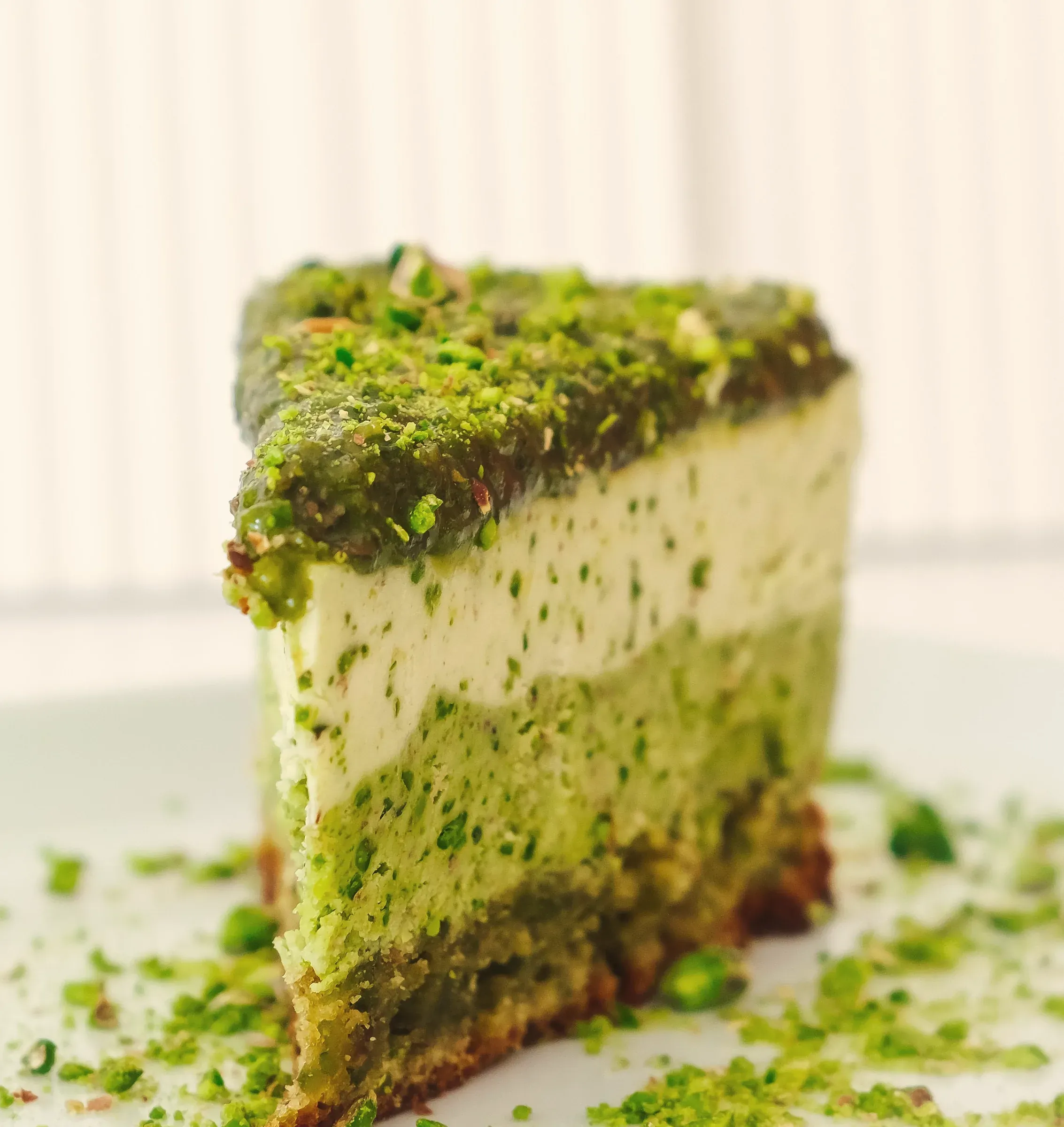 A slice of green matcha and pistachio cake