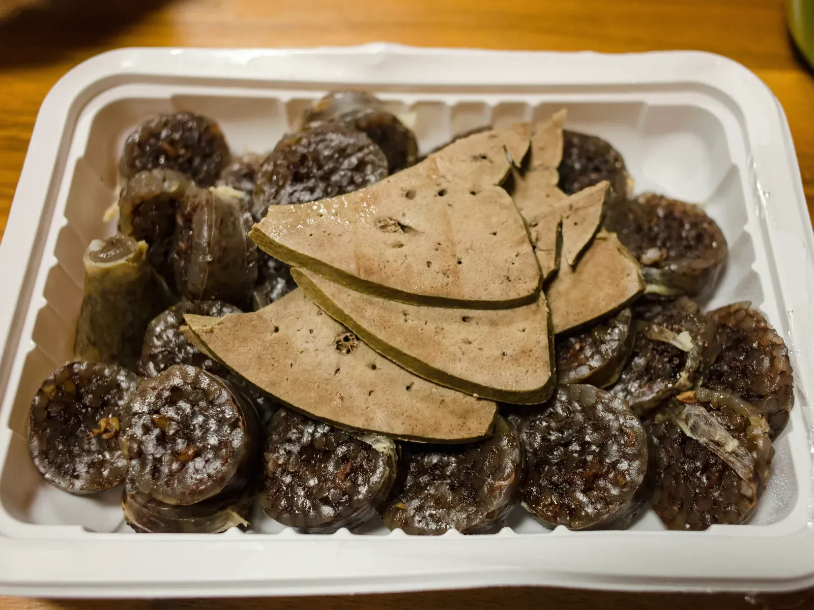 Sliced Korean sundae sausage with liver in a takeout tray