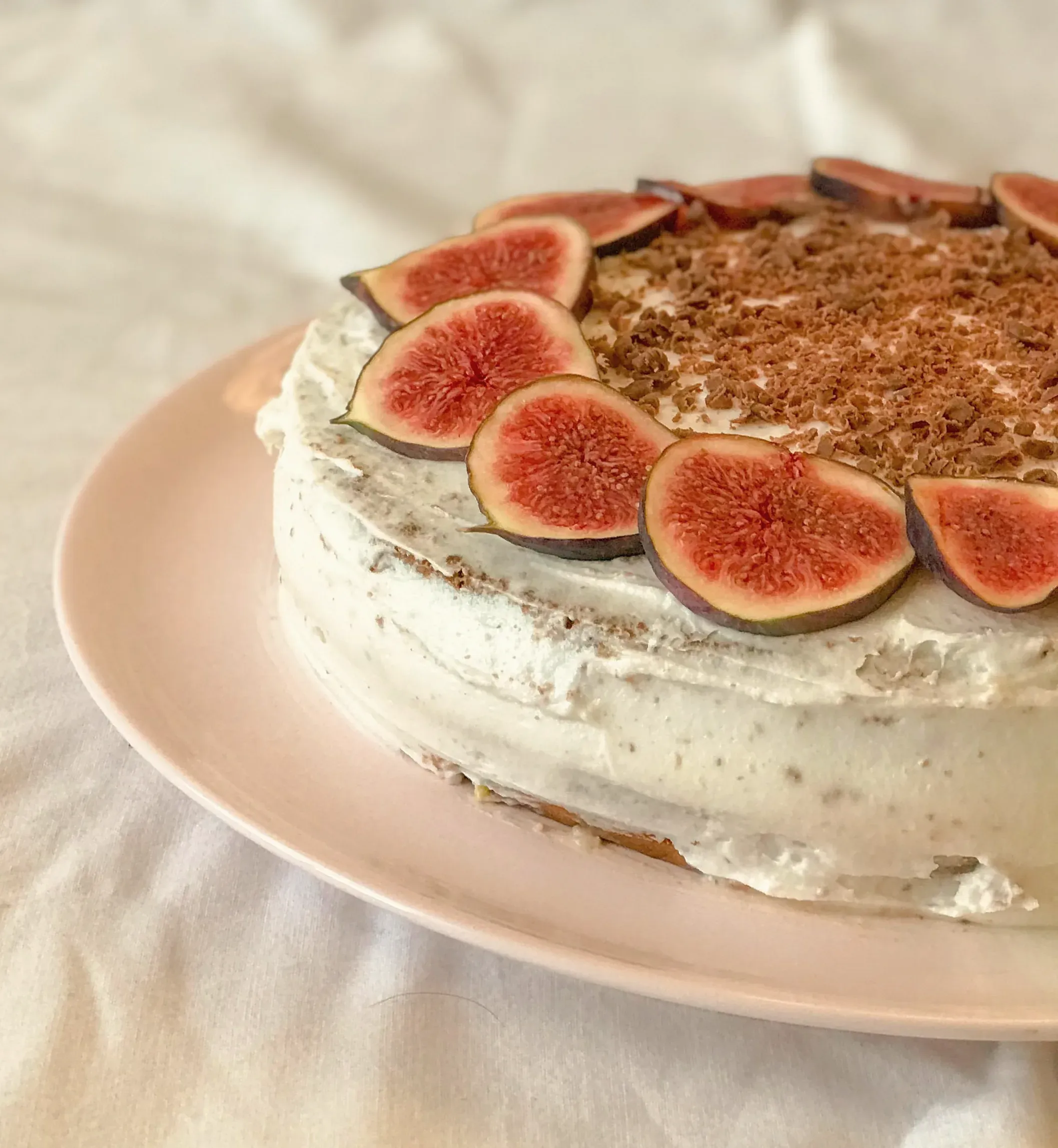 A cream cake topped with fresh figs